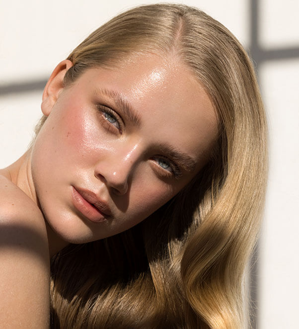 Blonde woman modeling with cross shadows