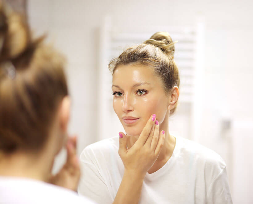 Woman examining her skin after a chemical peel